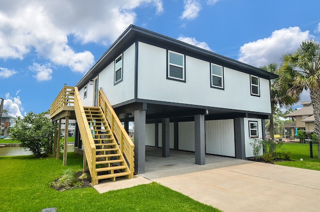 view of front of property featuring fence, stairs, driveway, a carport, and a front yard