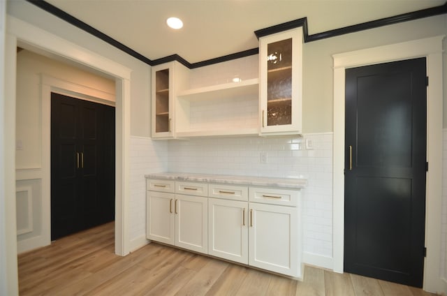 kitchen with light wood finished floors, glass insert cabinets, and white cabinetry