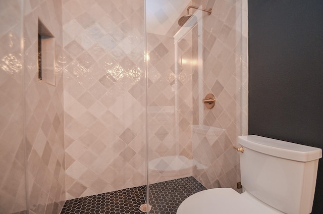 bathroom featuring toilet and tiled shower