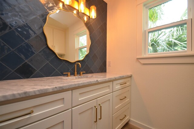 bathroom with tasteful backsplash, vanity, and baseboards