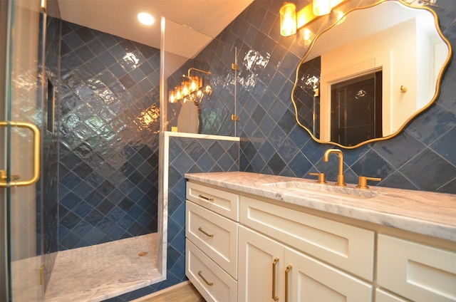 bathroom with backsplash, a tile shower, tile walls, and vanity