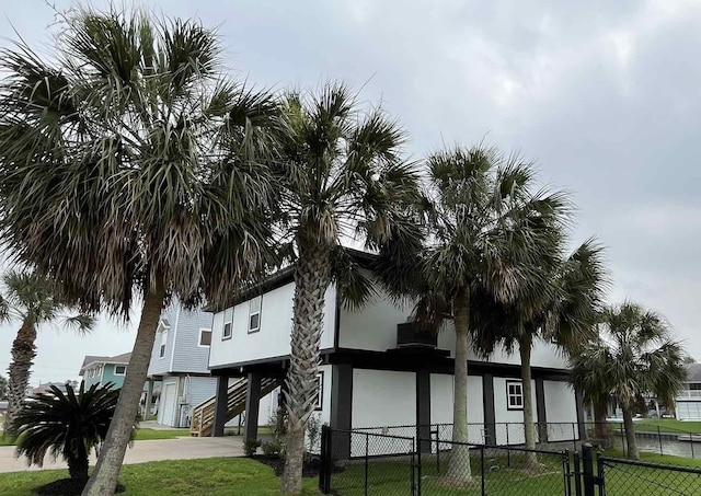 view of property featuring a carport, fence, and stairway