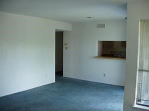 unfurnished living room featuring dark carpet