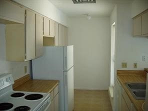 kitchen with white appliances, sink, and cream cabinets