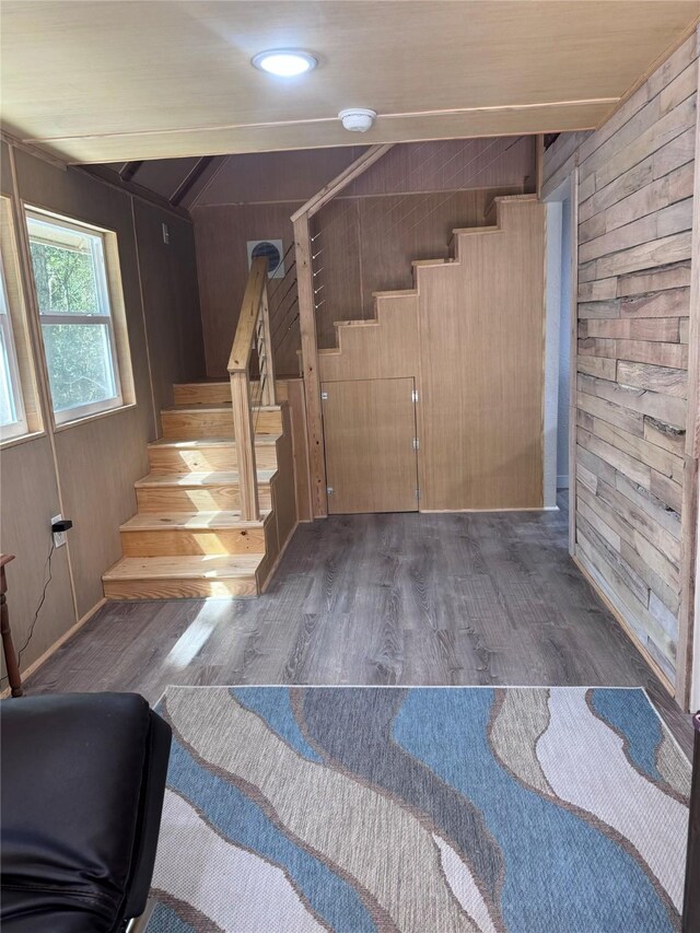 stairway featuring wood walls and hardwood / wood-style flooring