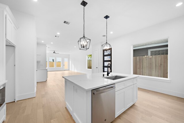 kitchen with ceiling fan with notable chandelier, light hardwood / wood-style flooring, stainless steel dishwasher, and white cabinets