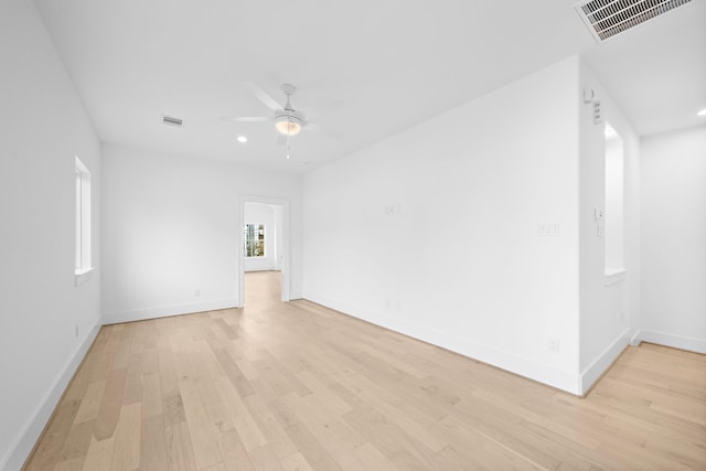 empty room featuring light wood-style flooring, visible vents, and ceiling fan