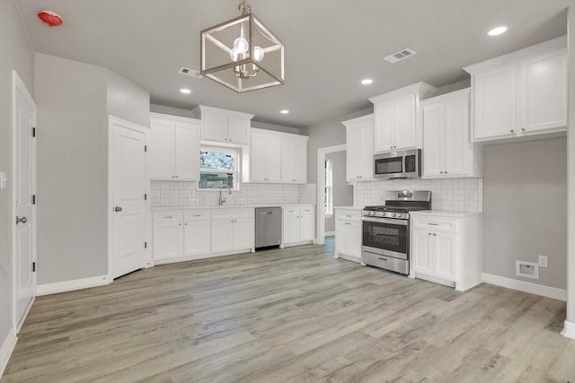 kitchen featuring sink, white cabinets, light hardwood / wood-style floors, and appliances with stainless steel finishes