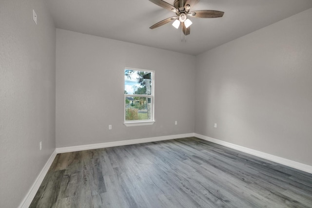 empty room with dark hardwood / wood-style flooring and ceiling fan