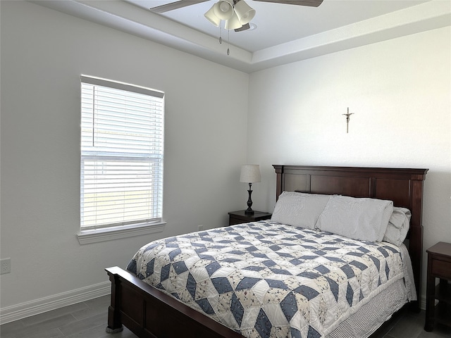 bedroom with ceiling fan, dark wood finished floors, and baseboards