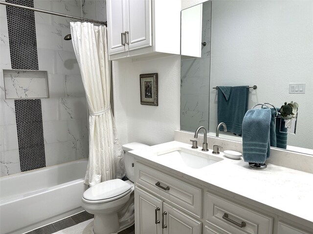 bathroom featuring toilet, a textured wall, shower / bathtub combination with curtain, and vanity