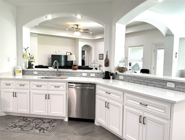 kitchen featuring white cabinets, dishwasher, light stone counters, sink, and kitchen peninsula