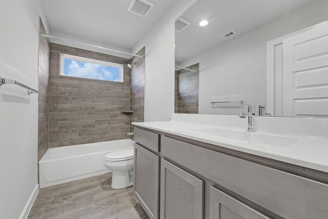 full bathroom featuring tiled shower / bath, toilet, vanity, and wood-type flooring