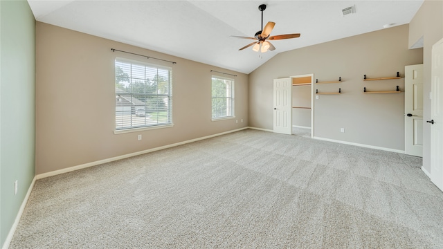 spare room featuring light carpet, vaulted ceiling, and ceiling fan