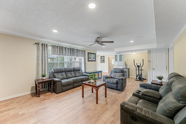 living area featuring baseboards, ornamental molding, a textured ceiling, light wood-type flooring, and recessed lighting