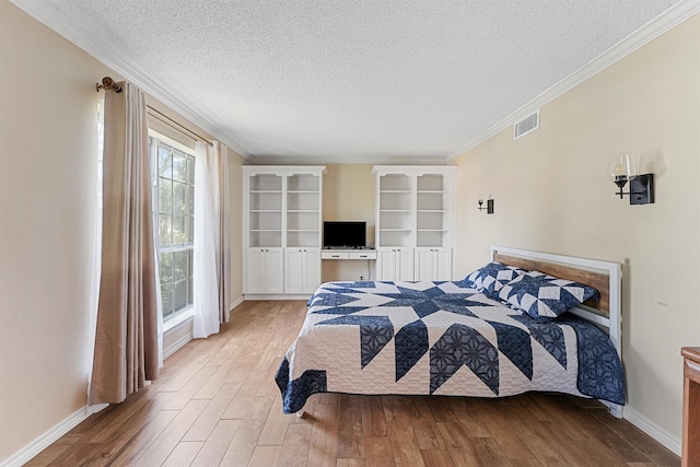 bedroom featuring light hardwood / wood-style floors, crown molding, and a textured ceiling