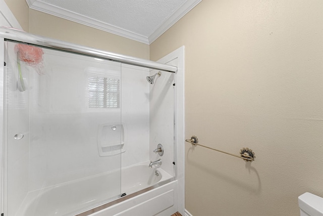 bathroom with a textured ceiling, ornamental molding, shower / bath combination with glass door, and toilet