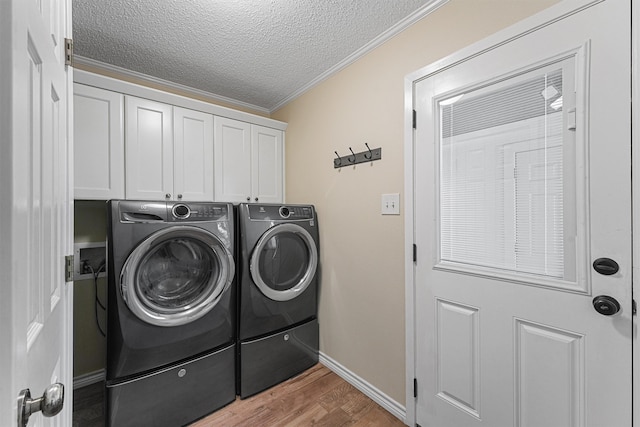 clothes washing area with independent washer and dryer, cabinets, crown molding, a textured ceiling, and hardwood / wood-style flooring