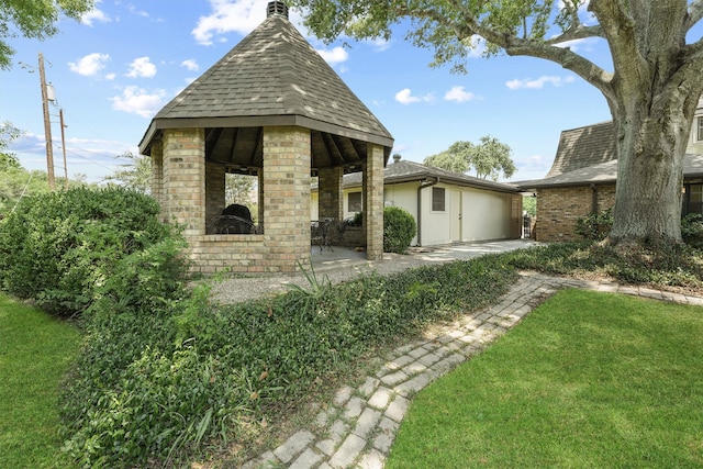 view of front of home with a gazebo, a front yard, and a patio area