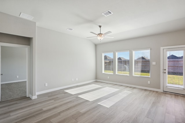 empty room featuring lofted ceiling, ceiling fan, and light wood-type flooring