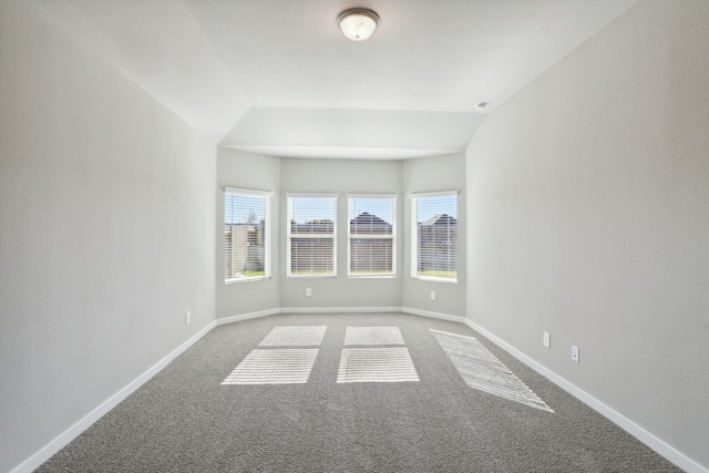 carpeted spare room with lofted ceiling