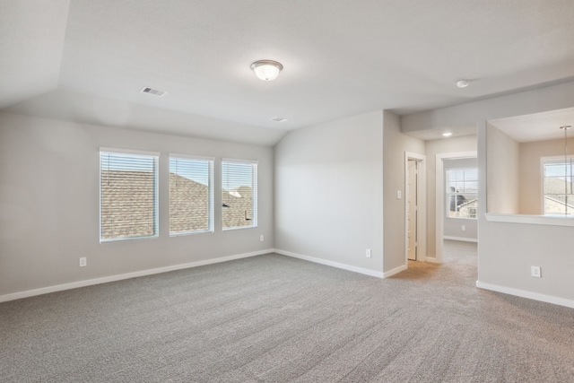 empty room with carpet flooring and vaulted ceiling