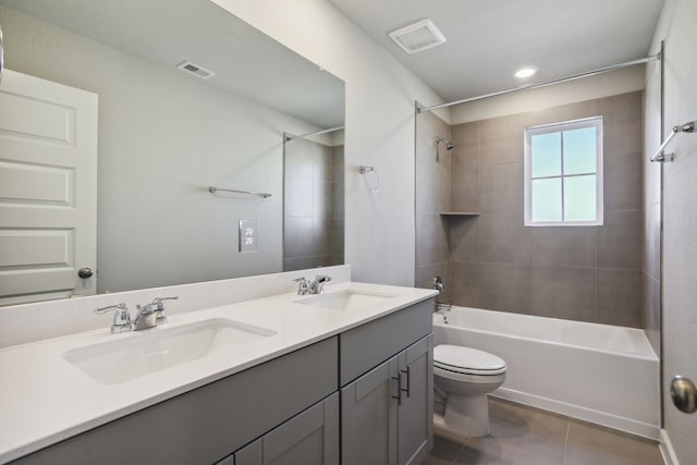 full bathroom with tiled shower / bath, vanity, toilet, and tile patterned floors