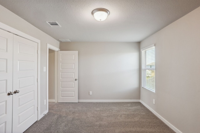 interior space featuring carpet, a textured ceiling, and a closet