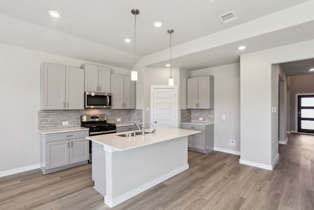 kitchen featuring sink, gray cabinetry, light hardwood / wood-style flooring, pendant lighting, and stainless steel appliances