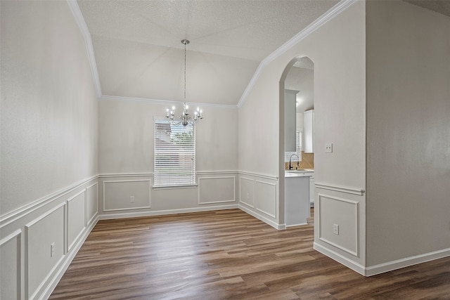 unfurnished dining area with lofted ceiling, wood-type flooring, a chandelier, and a textured ceiling