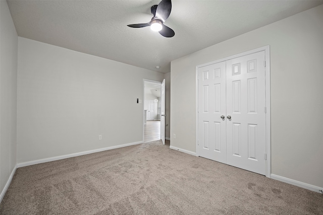 unfurnished bedroom featuring ceiling fan, light colored carpet, and a closet