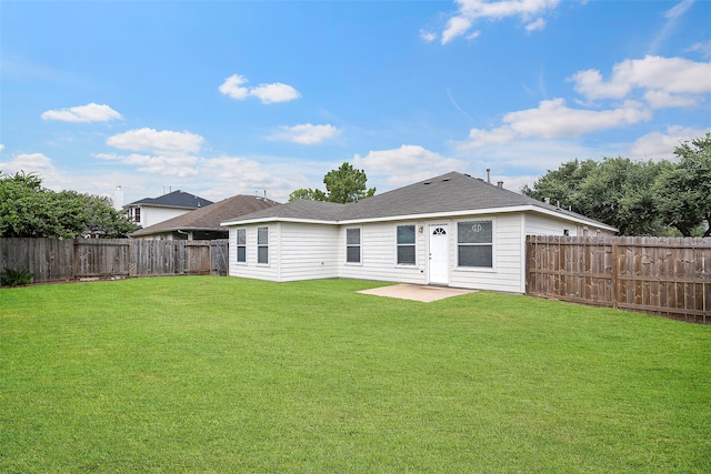 back of house featuring a lawn and a patio area