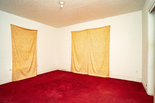 empty room with a textured ceiling and carpet