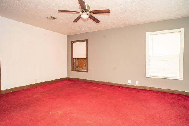 unfurnished room featuring a textured ceiling, carpet flooring, and ceiling fan