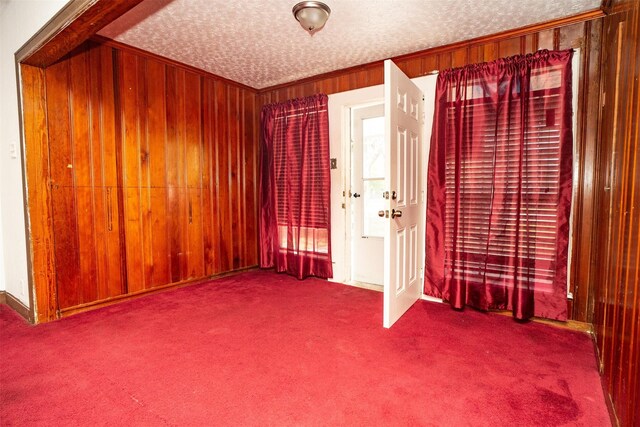 unfurnished room featuring carpet, crown molding, and a textured ceiling