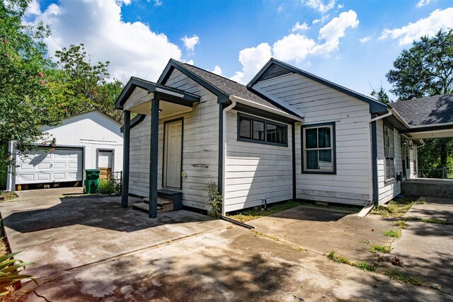 rear view of property with a garage and an outdoor structure