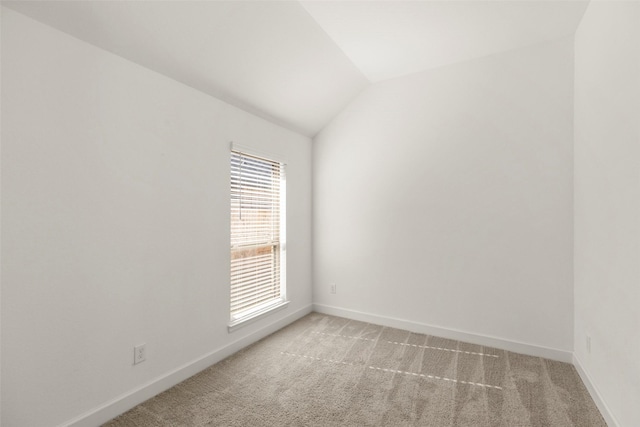 unfurnished room with light colored carpet and lofted ceiling