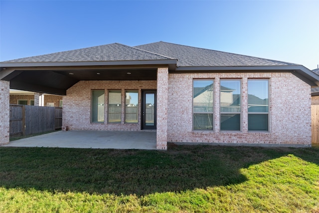 rear view of house with a yard and a patio