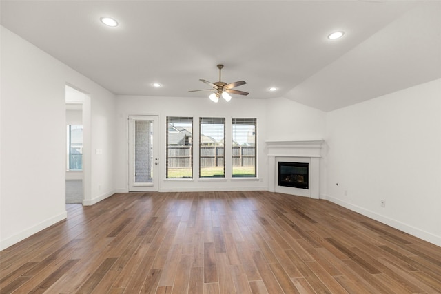 unfurnished living room with ceiling fan, wood-type flooring, and vaulted ceiling