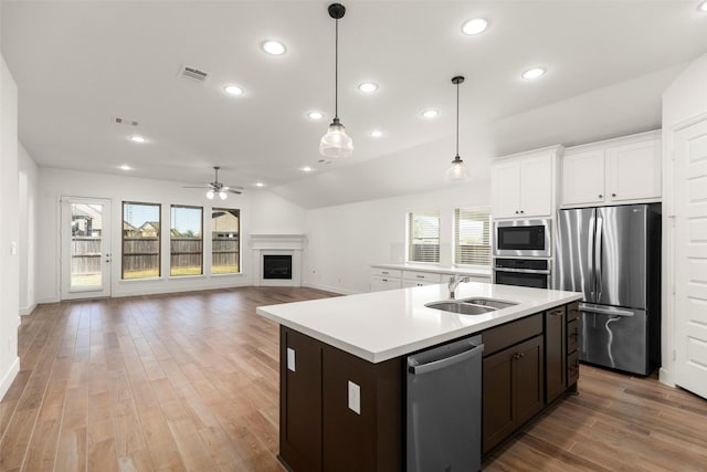 kitchen with stainless steel appliances, white cabinetry, a healthy amount of sunlight, and sink