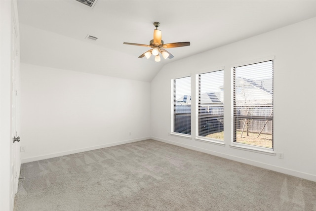 carpeted spare room with ceiling fan and vaulted ceiling