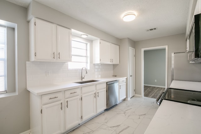 kitchen featuring light wood-type flooring, backsplash, dishwasher, sink, and white cabinets