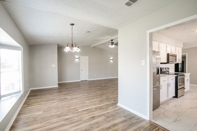 interior space with ceiling fan with notable chandelier, lofted ceiling with beams, a textured ceiling, and light hardwood / wood-style flooring