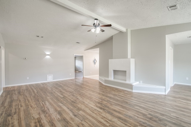 unfurnished living room with hardwood / wood-style flooring, ceiling fan, and vaulted ceiling with beams