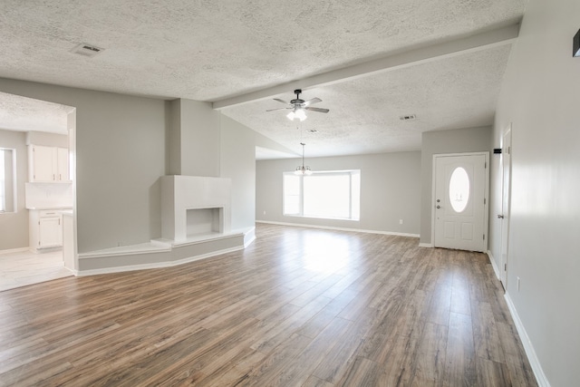 unfurnished living room with wood-type flooring, ceiling fan, and a textured ceiling