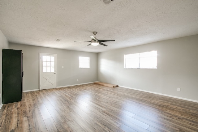 empty room featuring a textured ceiling, wood-type flooring, and ceiling fan