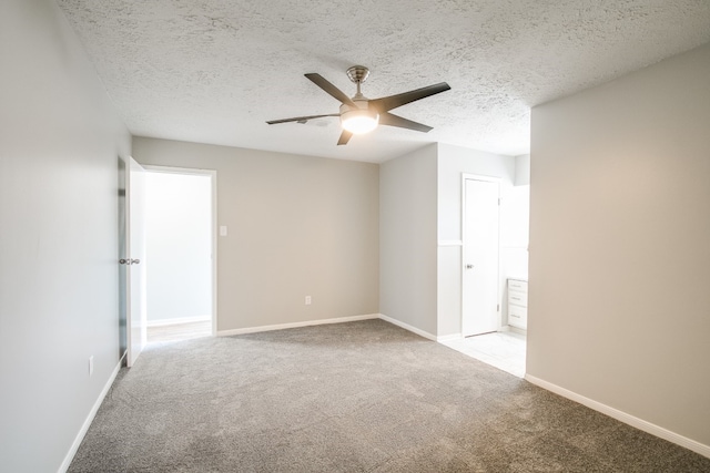 carpeted empty room featuring ceiling fan and a textured ceiling