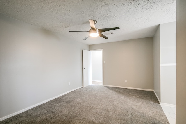 carpeted empty room with ceiling fan and a textured ceiling