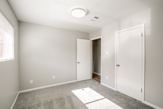 unfurnished bedroom featuring a closet and light carpet