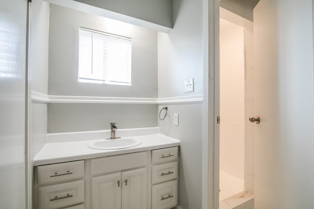 bathroom featuring a tile shower and vanity